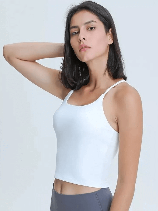 Woman wearing a white sports elastic breathable tank top with adjustable straps, ideal for fitness activities.
